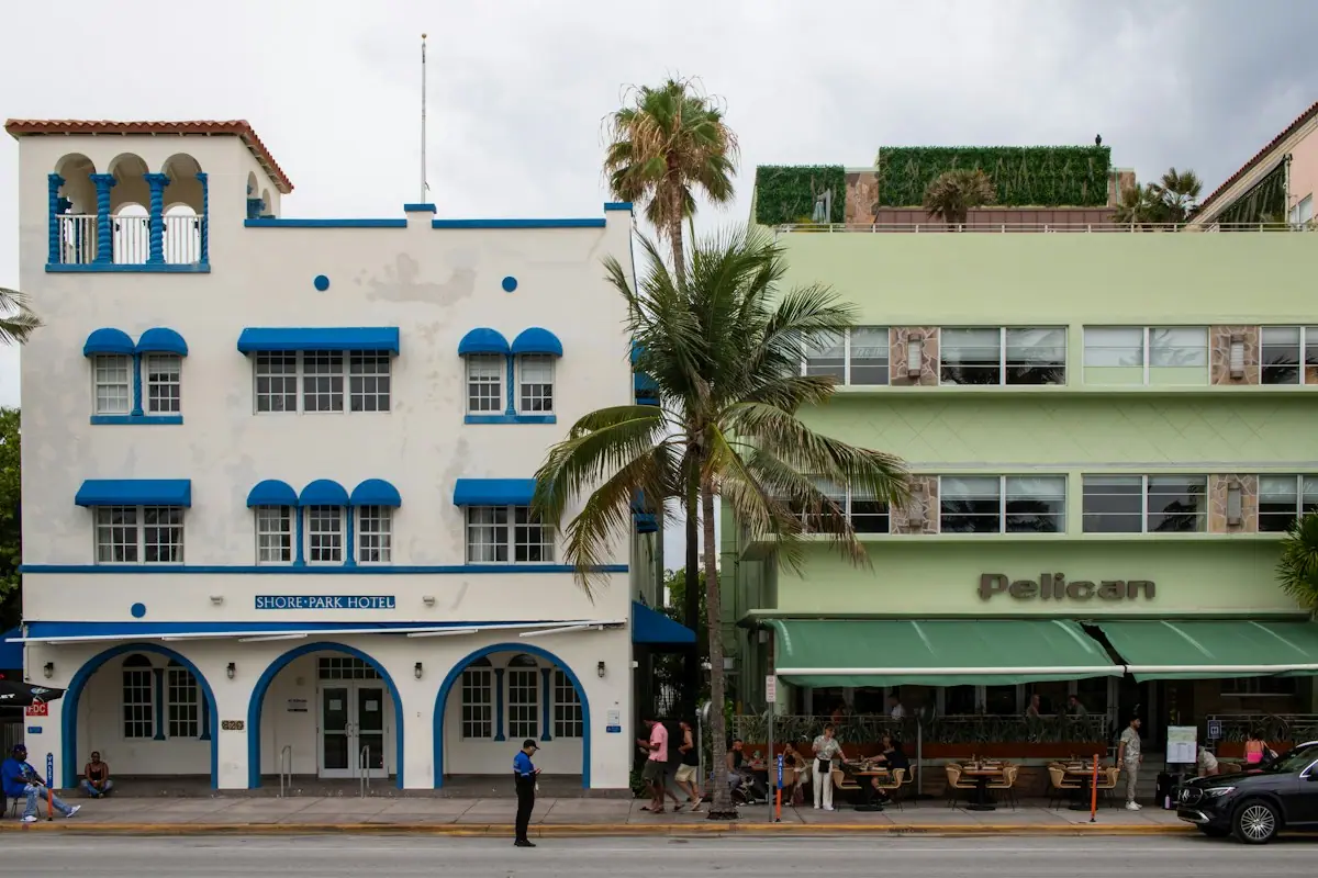 A white Art Deco building with blue trim on a Miami Beach street corner